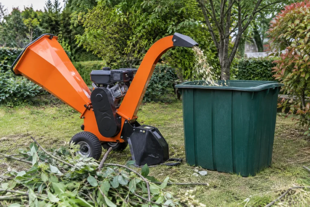 Broyeur de branches dont la goulotte d’éjection est dirigée vers un bac placé sur le côté.